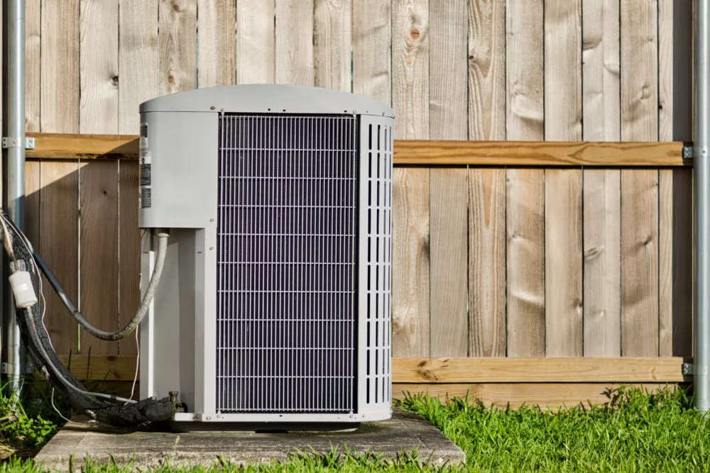 Outdoor AC unit next to wooden fence