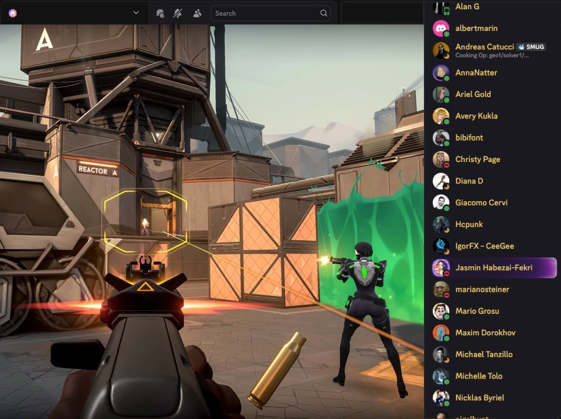 First-person shooter game view aiming at a distant opponent near a reactor labeled A, with a teammate shooting beside a green barrier and a player list on the right side.