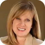 Smiling woman with straight blonde hair wearing a beige blazer against a neutral background.