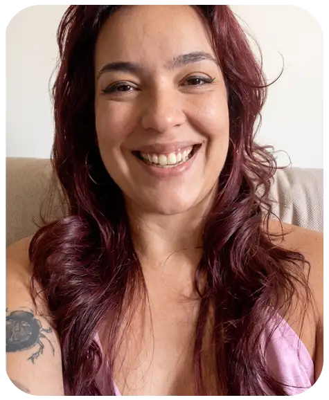 Retrato en primer plano de una mujer riendo con fondo rojo.