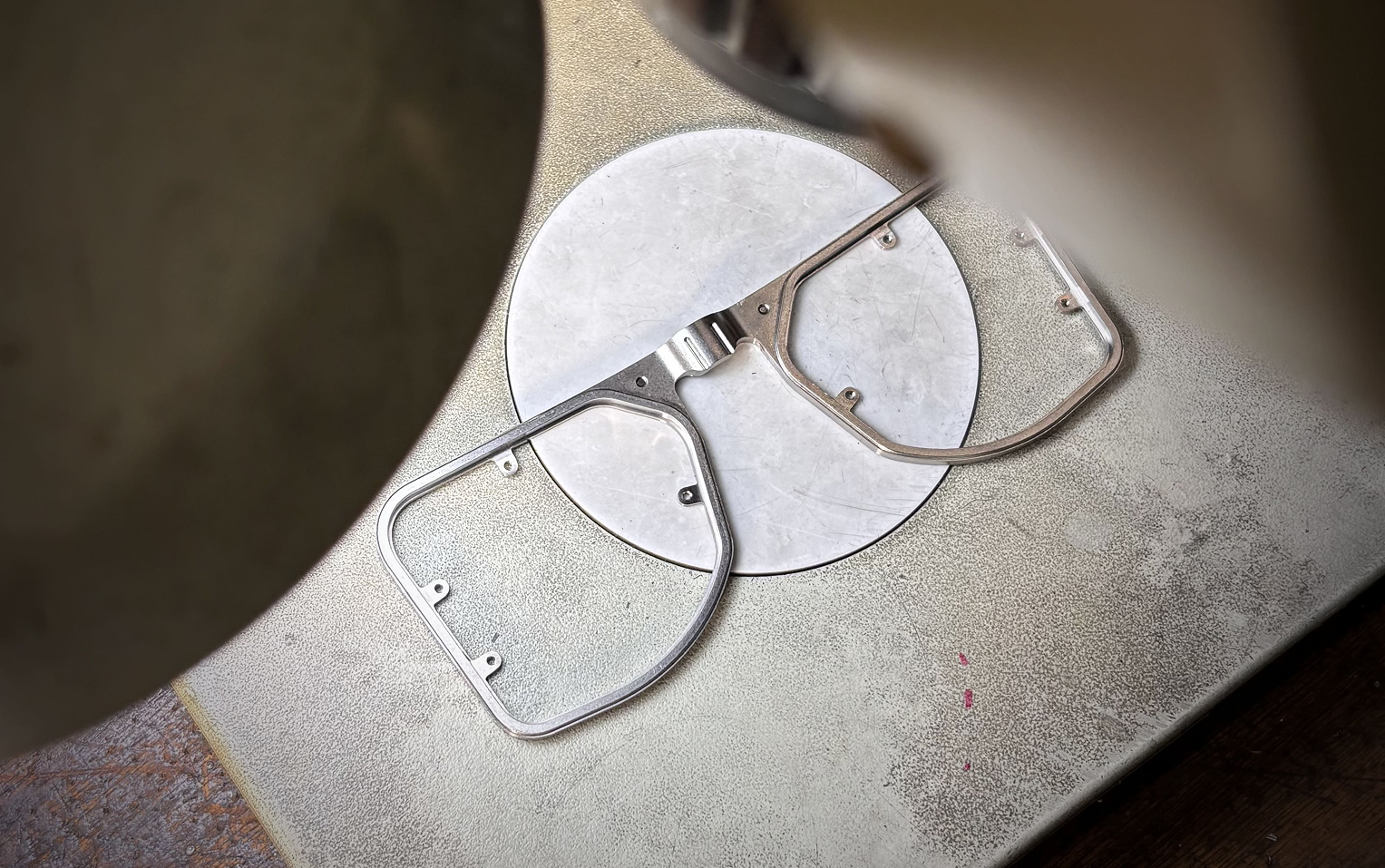 An overhead view of a single metallic DRK frame on a precision workshop jig, awaiting the next stage of meticulous assembly.