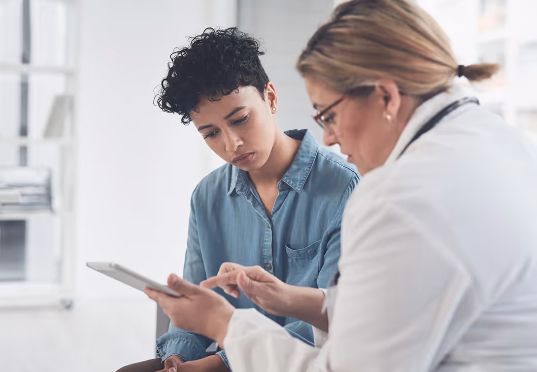 Women in Great Neck, NY explores membership benefits for concierge health on a tablet.