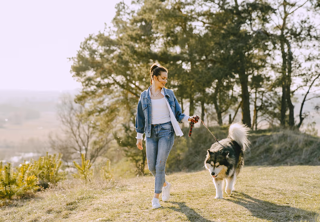 Woman in Great Neck, NY, enjoys optimized health with custom-built, personalized care, walking a dog.
