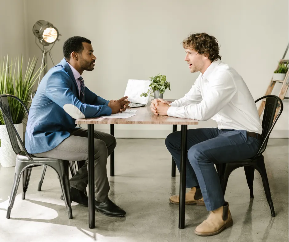 Job interview between employer and candidate at office table.