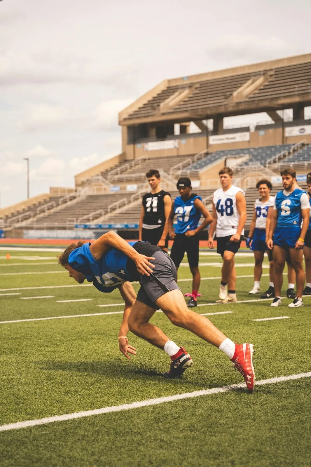 College football players running drills at practice. 
