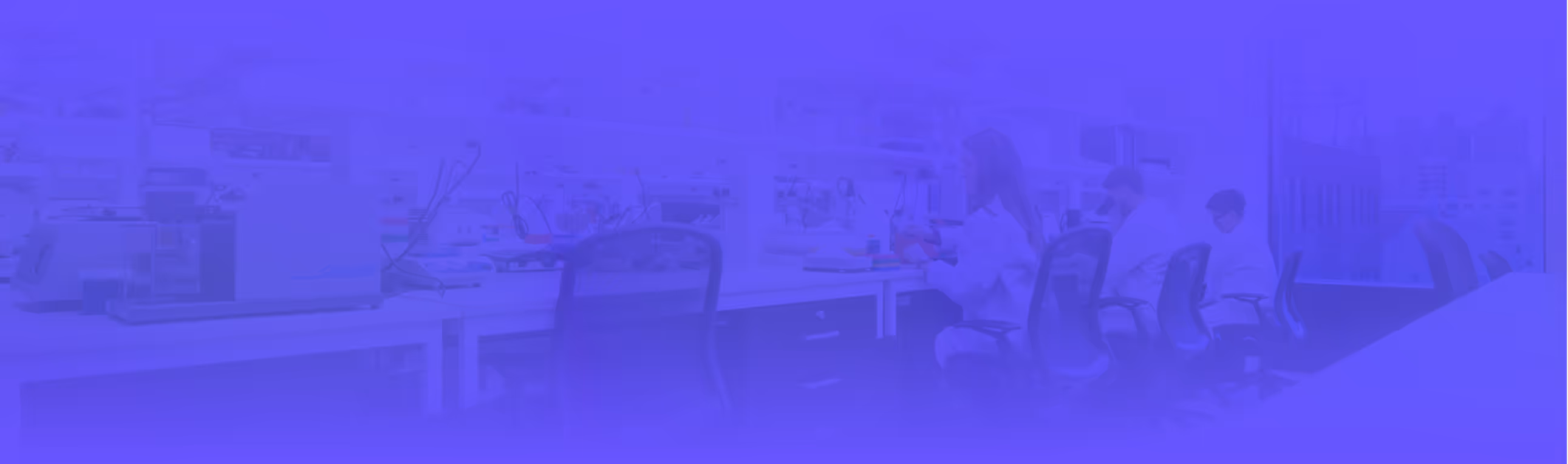 Laboratory setting with scientists in white coats working at benches with equipment and instruments.