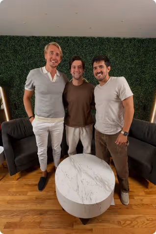 Ben and two ment standing in front of a green wall and taking a picture