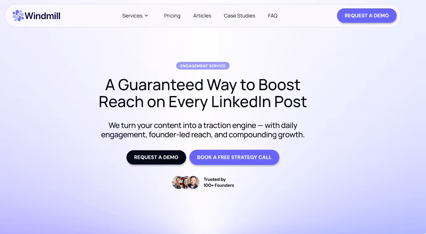 Two men sitting at a table in an office, one smiling and gesturing with his hands, the other relaxed and smiling.