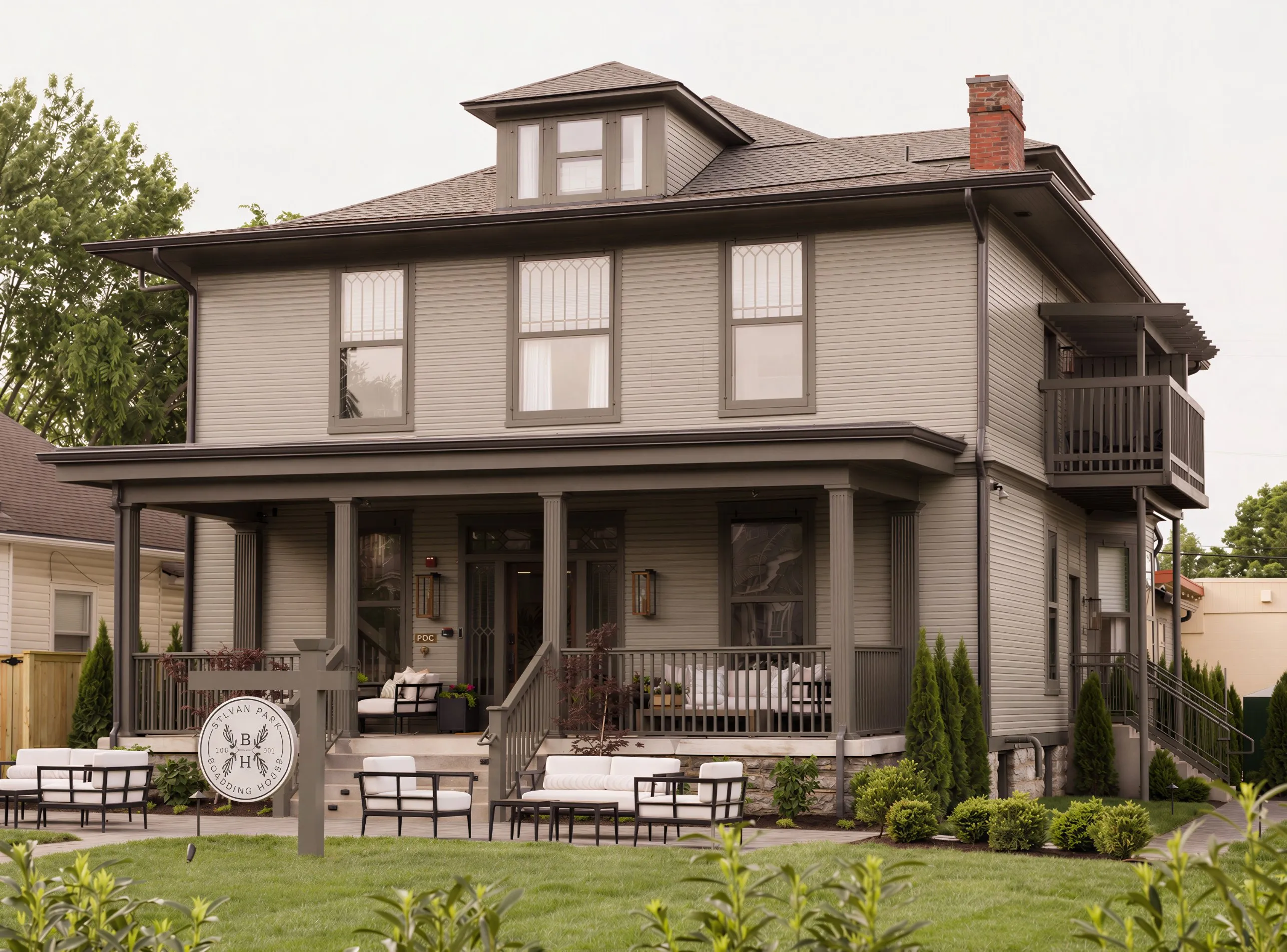 Sylvan Park Boarding House, a restored 1910 home in Nashville, with its wide front porch, lawn seating and round crest sign