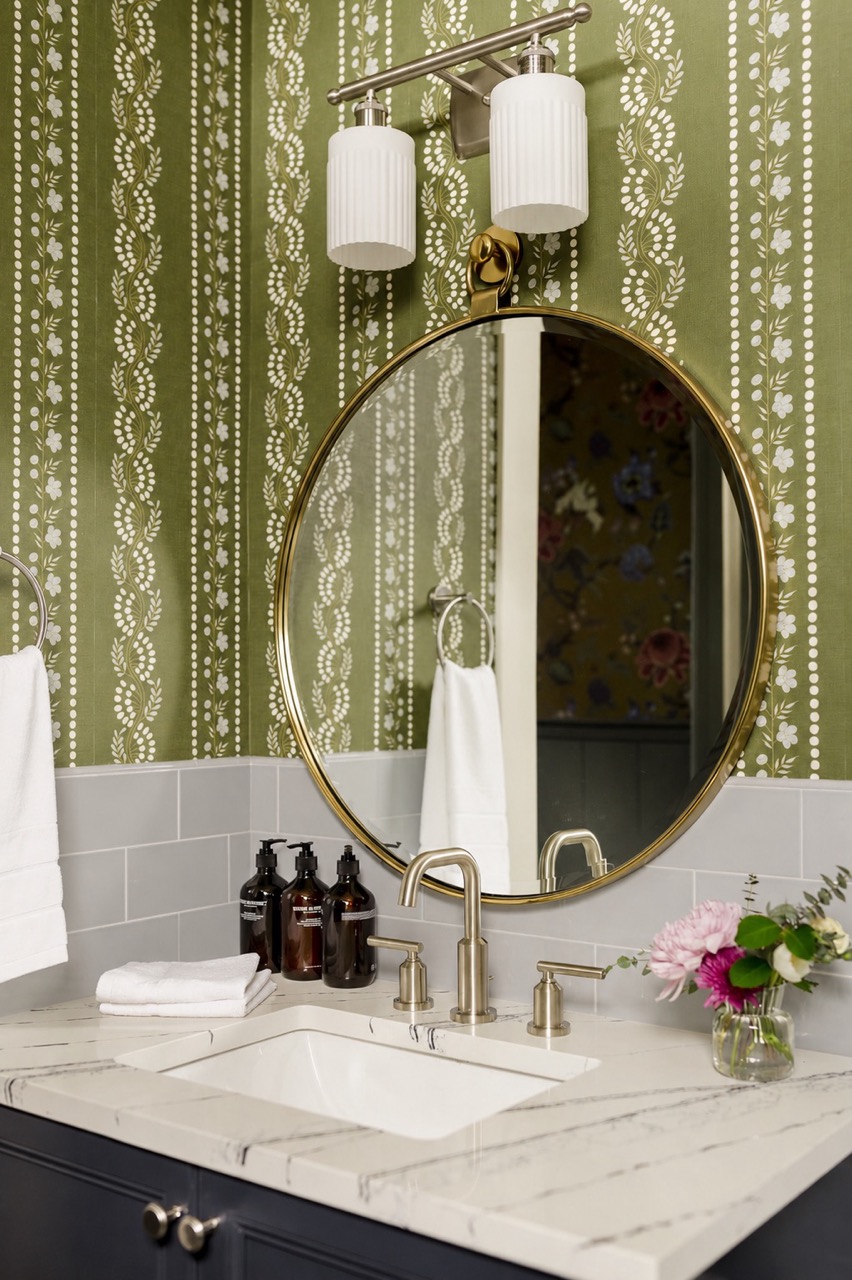 Round brass mirror and green botanical wallpaper in the bathroom, The Cohn suite