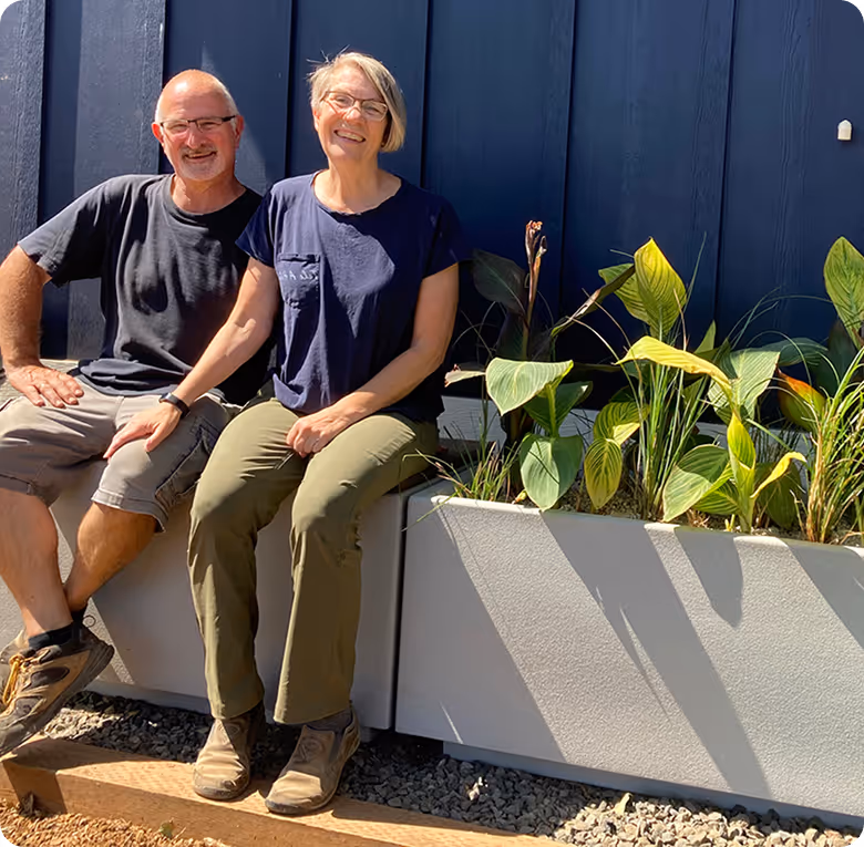 A man and a woman are sitting on a wall.