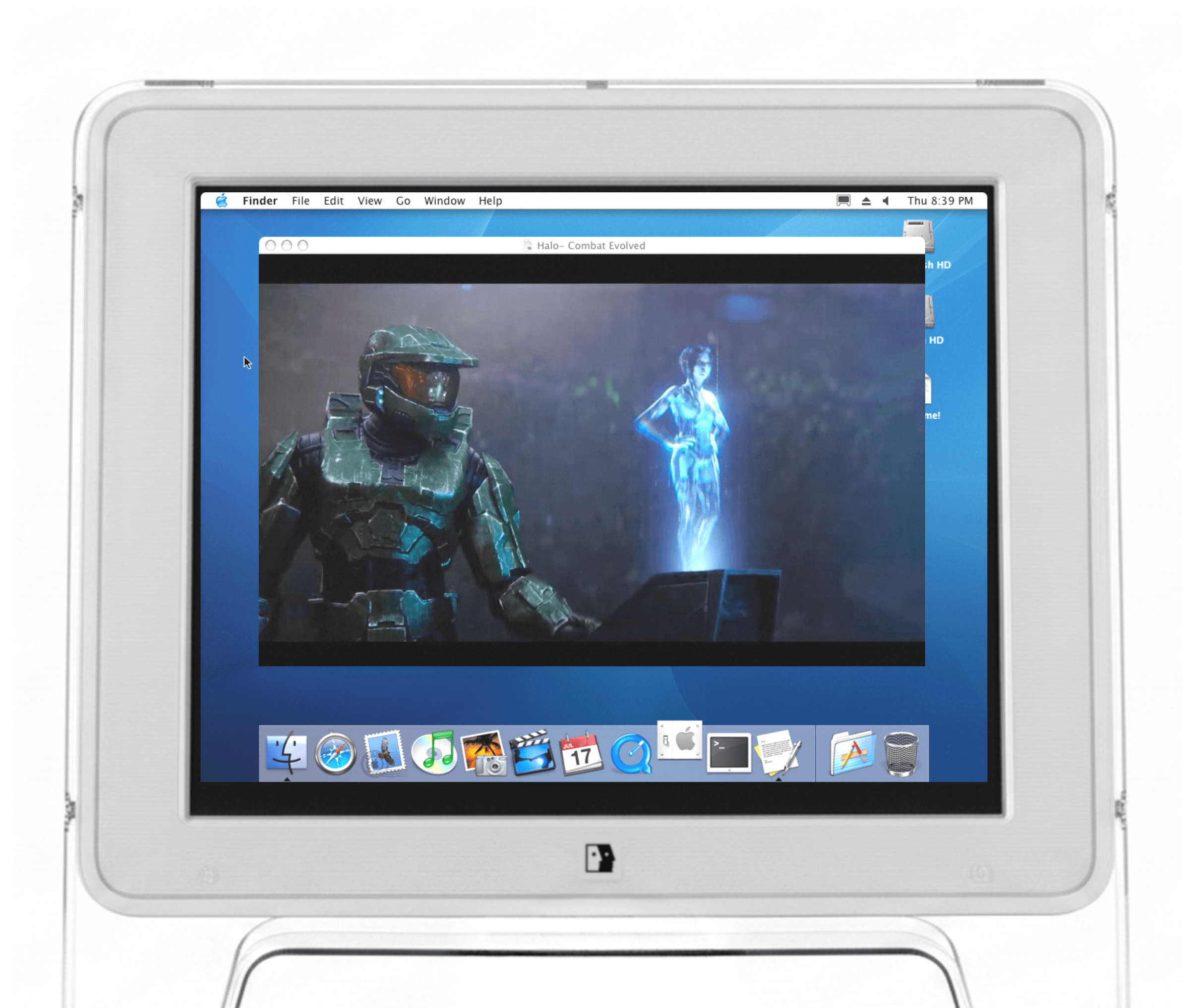 A vintage translucent Apple iMac computer displays a desktop screen running an old Mac OS interface, with a window open showing a scene from the video game Halo: Combat Evolved featuring the character Master Chief and a blue holographic figure.