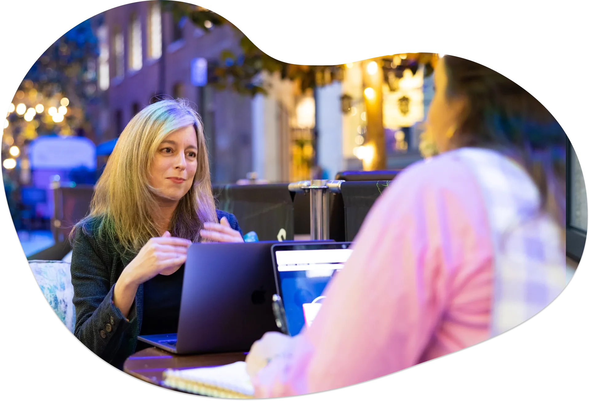 A sales coaching session between a manager and a rep at a cafeteria table