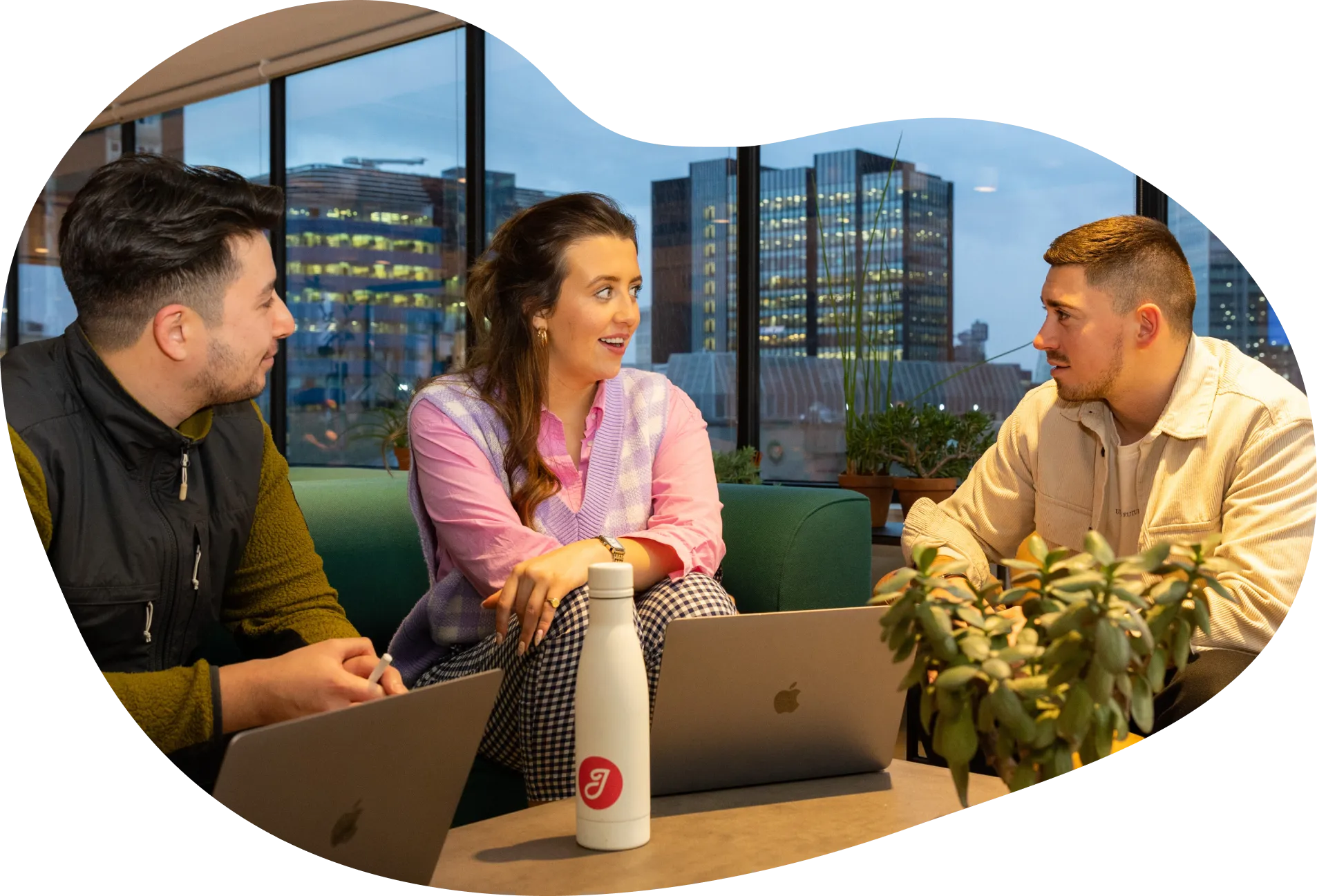 Three Jiminny employees working in an open-plan office