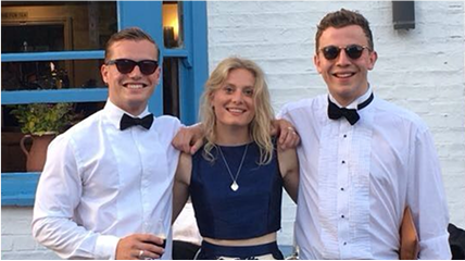 Jack, Laura, and Lewis smiling and standing together at a formal event