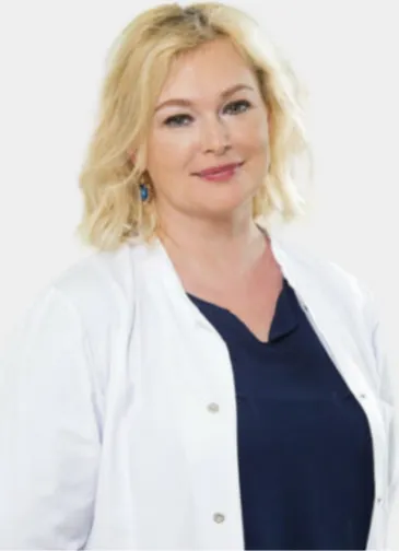 Smiling woman with blonde hair wearing a white lab coat and navy blue top. Specialist in gynecology Rasa Aleksiene