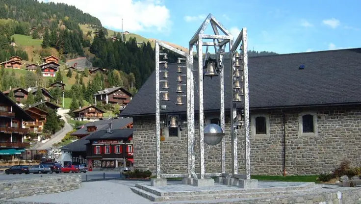 Le Carillon de Morgins devant l’église Saint-Théodule, symbole de paix dans les Alpes valaisannes