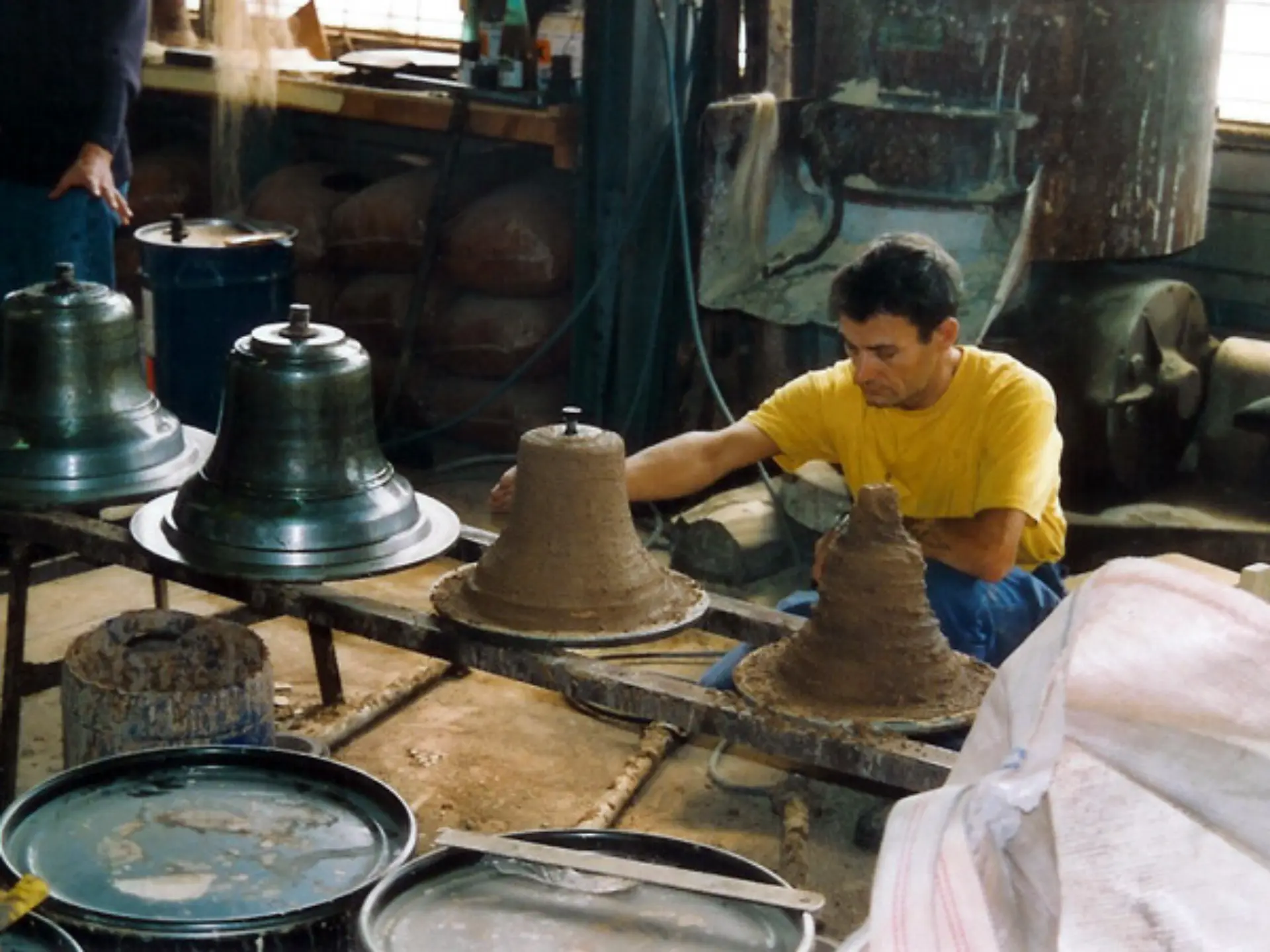 Artisan façonnant les cloches du Carillon de Morgins dans un atelier traditionnel