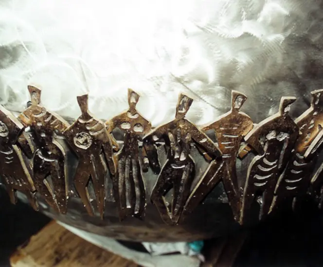 Détail de la chaîne humaine en métal entourant la mappemonde du Carillon de Morgins, symbole de solidarité