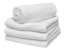 Four white towels stacked on top of each other.