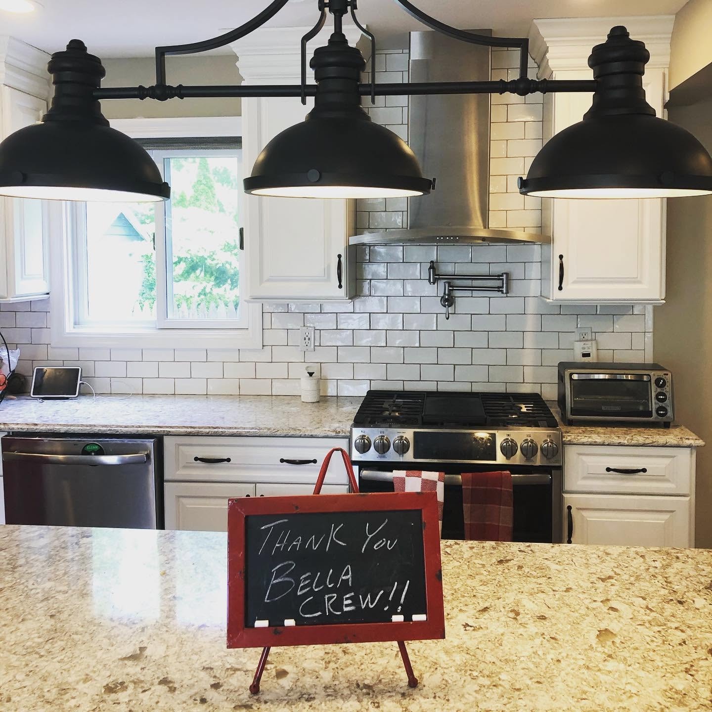 Freshly cleaned kitchen with a "Thank you Bella crew" chalkboard sign on the counter