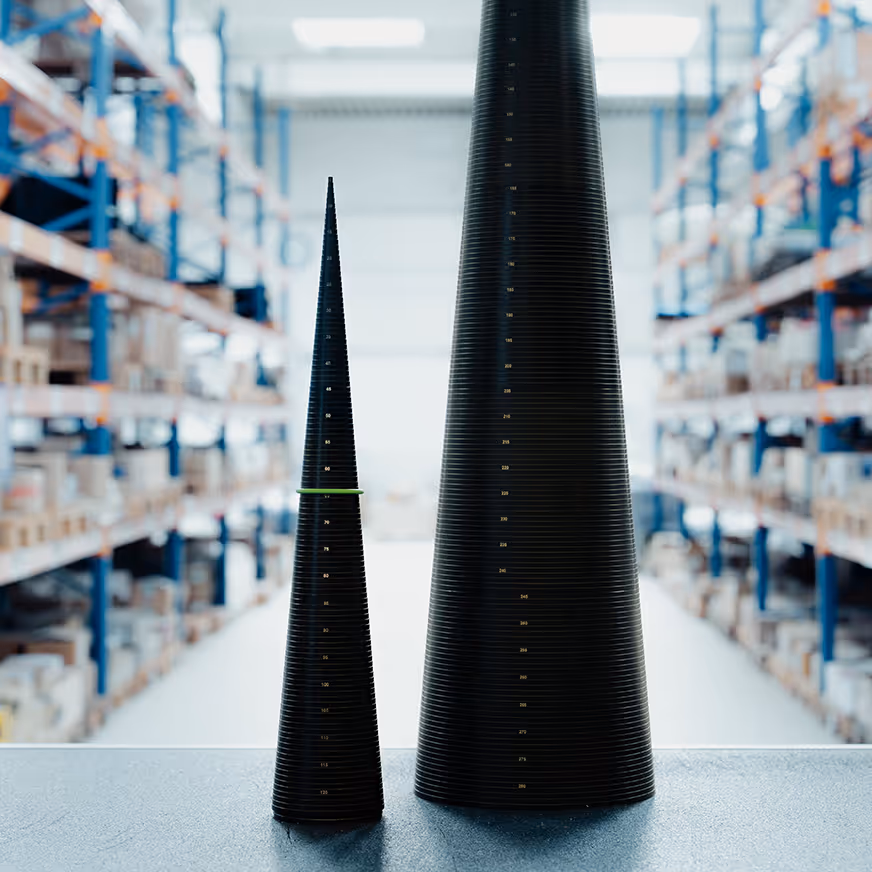 Zwei schwarze kegelförmige Messinstrumente mit Skalen stehen auf einem Tisch in einem Lagerhaus.