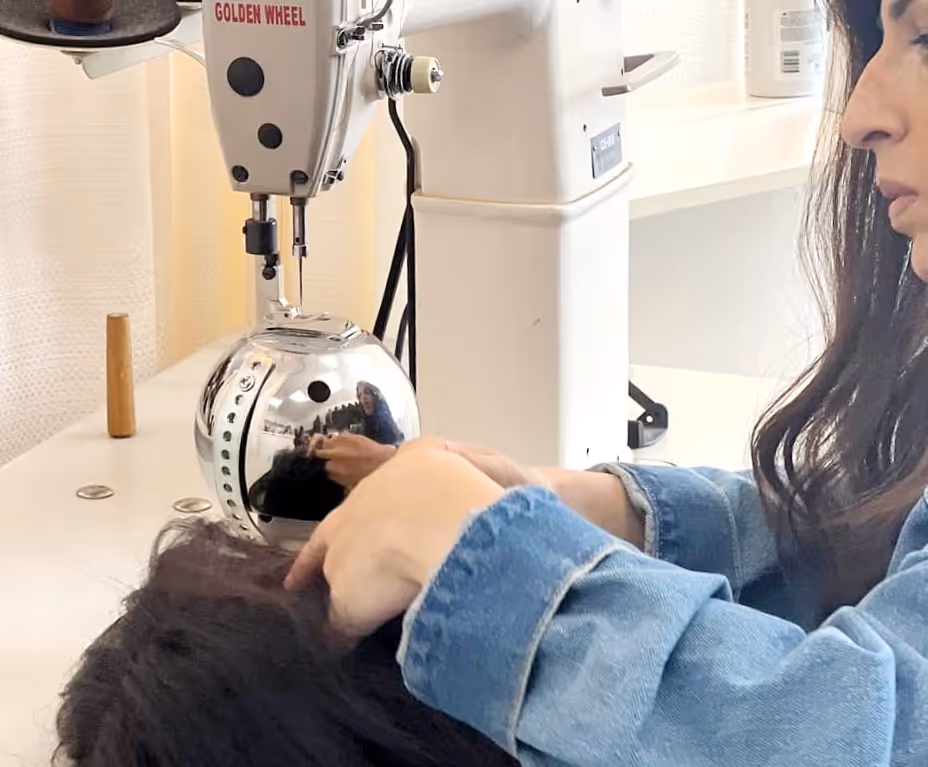 Une personne en veste en jean utilisant une machine médicale blanche avec une partie sphérique pour traiter les cheveux d'une autre personne allongée.