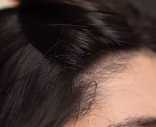 Gros plan sur une raie de cheveux foncés soigneusement coiffés près du cuir chevelu.