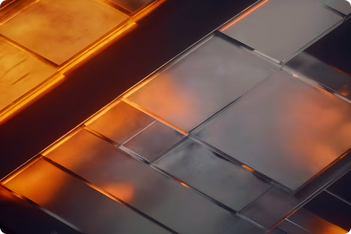 Close-up of translucent rectangular glass tiles with orange and purple lighting reflections.