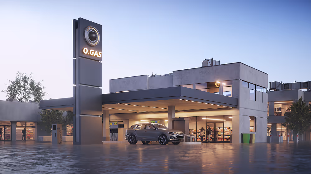 Modern gas station building with a sleek silver car parked under the canopy during early evening.