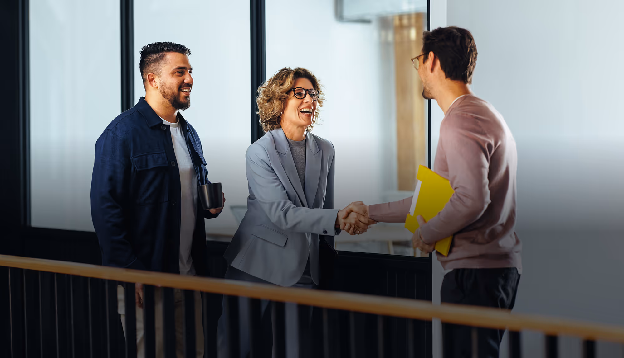 Professionals discussing work together in a modern office environment, representing collaboration and recruitment support.