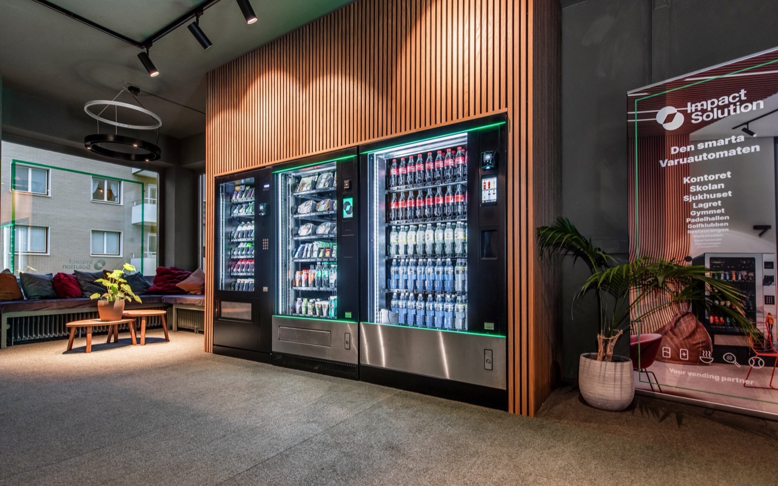 Impact Solutions showroom i Uppsala med tre varuautomater mot en träribbvägg