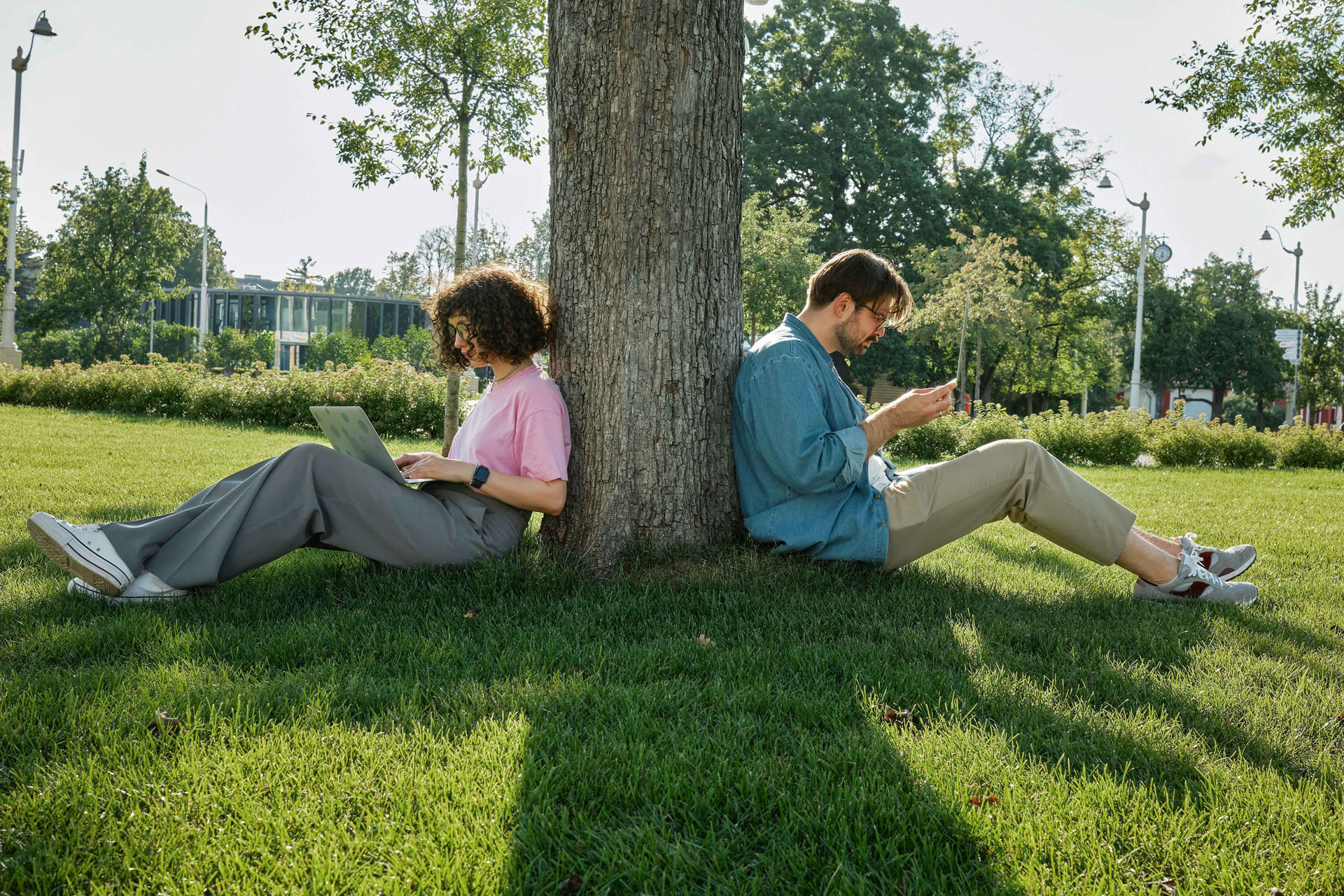 Zwei Personen sitzen auf einer Wiese und lernen