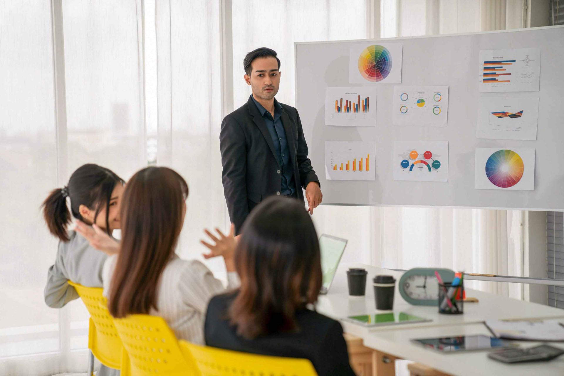 Dozent präsentiert vor kleiner Klasse mit Whiteboard
