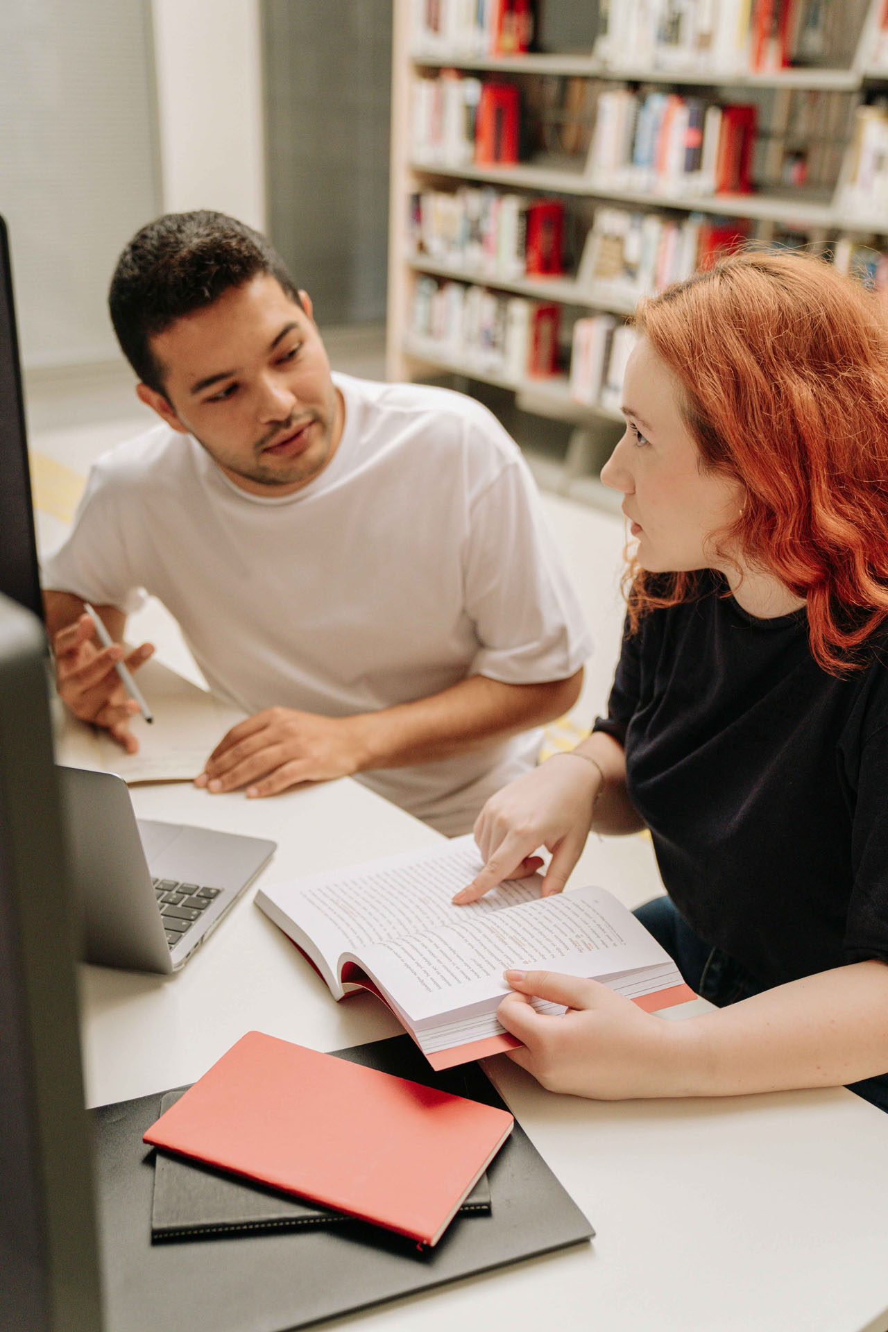 Student arbeitet mit seiner Kollegin konzentriert an einem Tisch