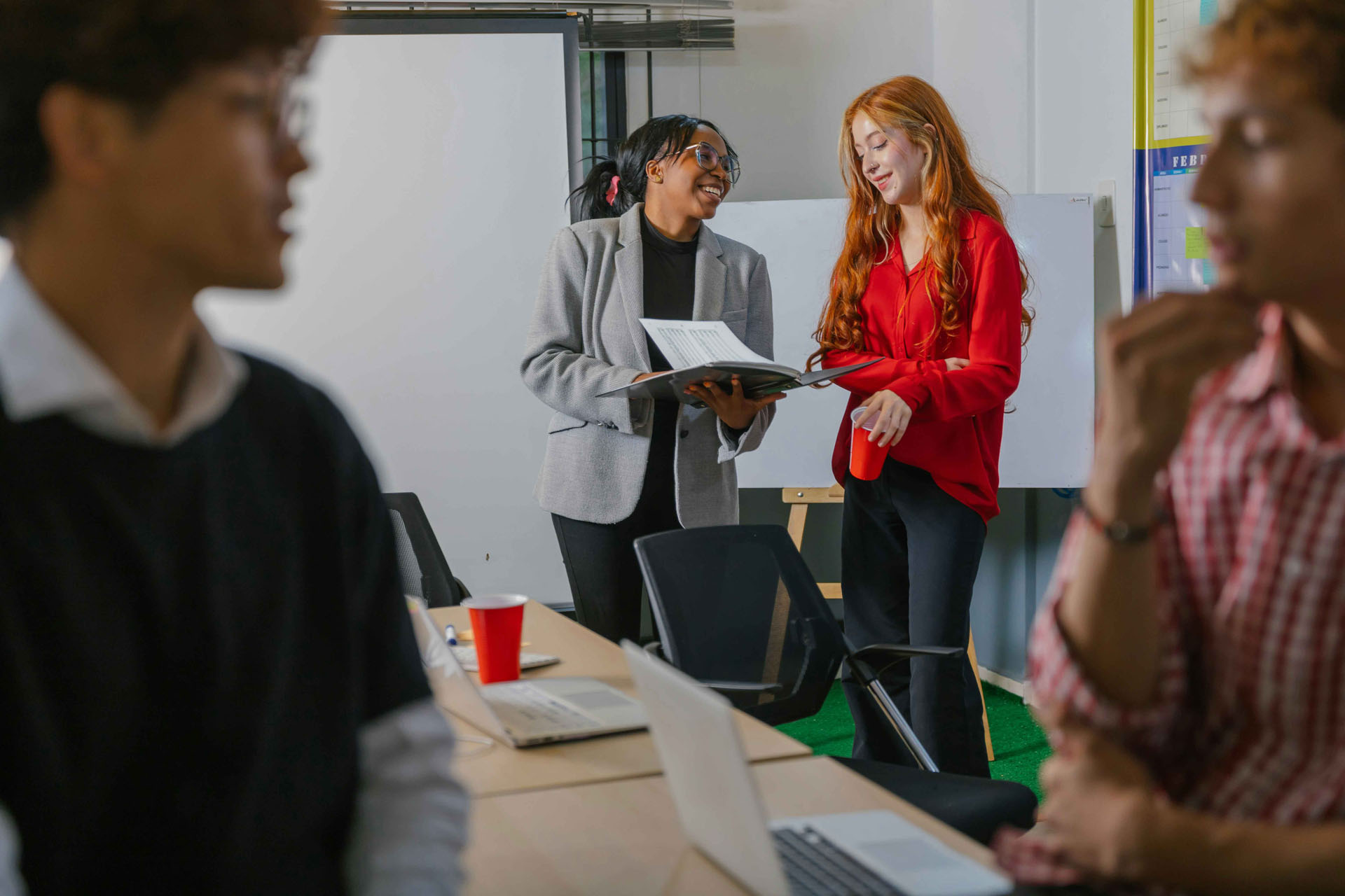 Team-Workshop mit Dokumenten, Laptops und Whiteboard