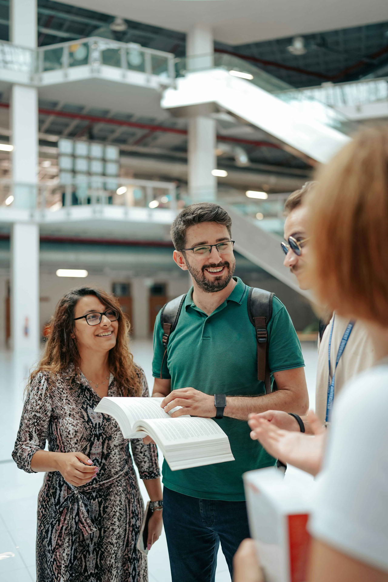 Vier Personen tauschen sich lachend im Treppenhaus aus