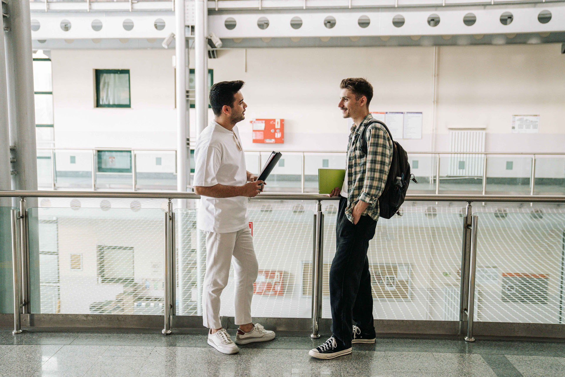 Zwei Personen unterhalten sich in einem leeren Flur