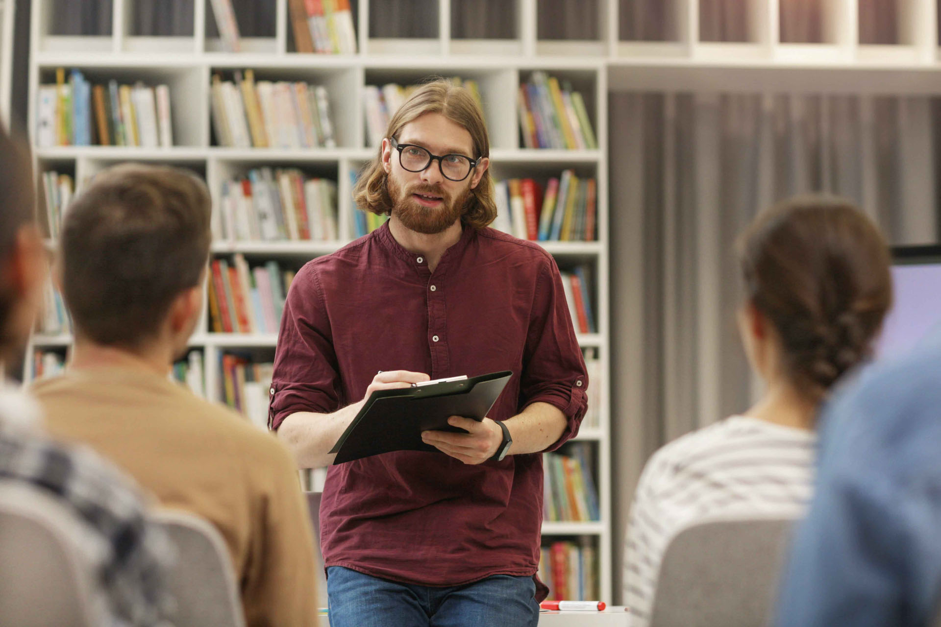 Dozent spricht vor kleiner Gruppe in einer Bibliothek