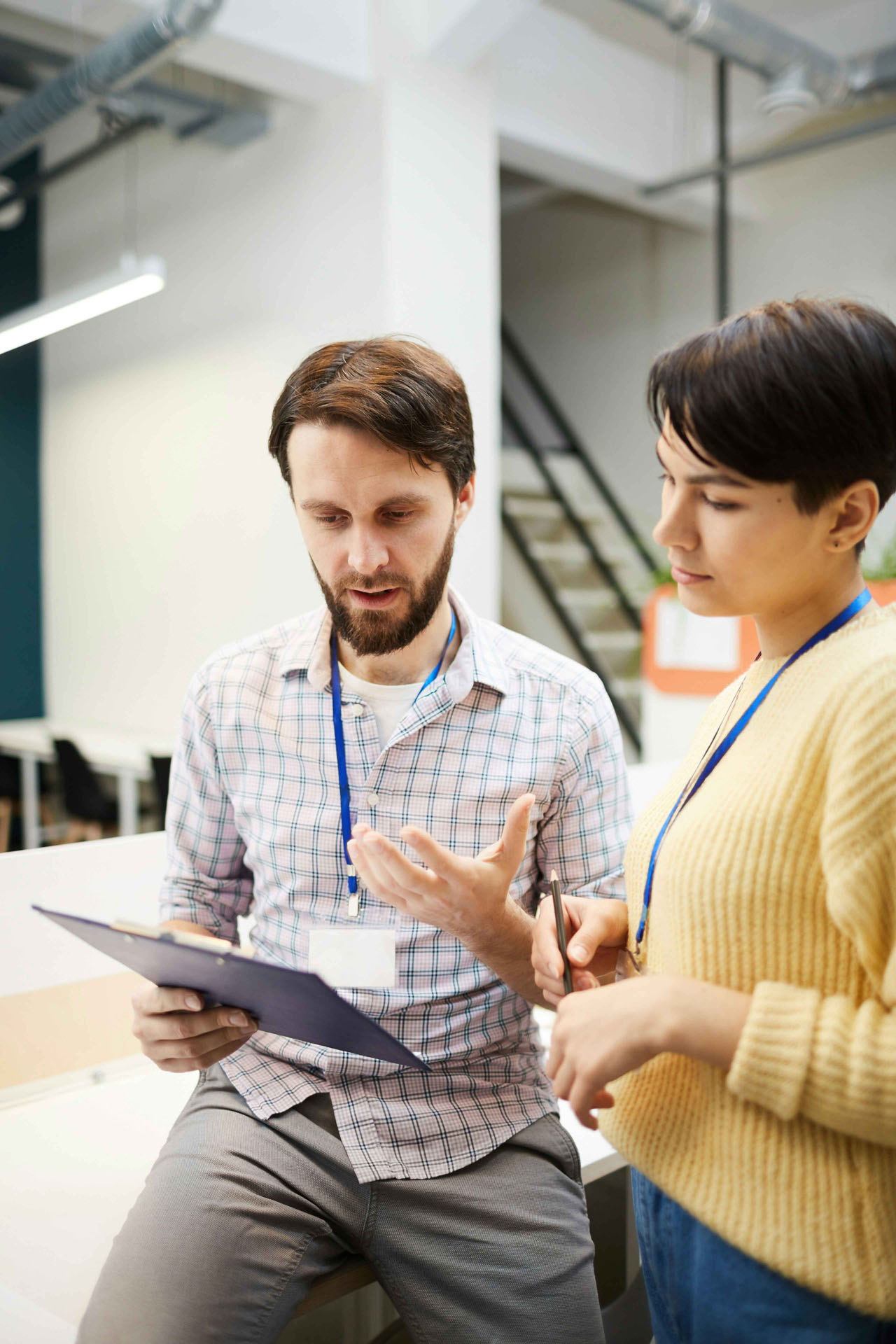 Zwei Personen besprechen Inhalte auf Klemmbrett