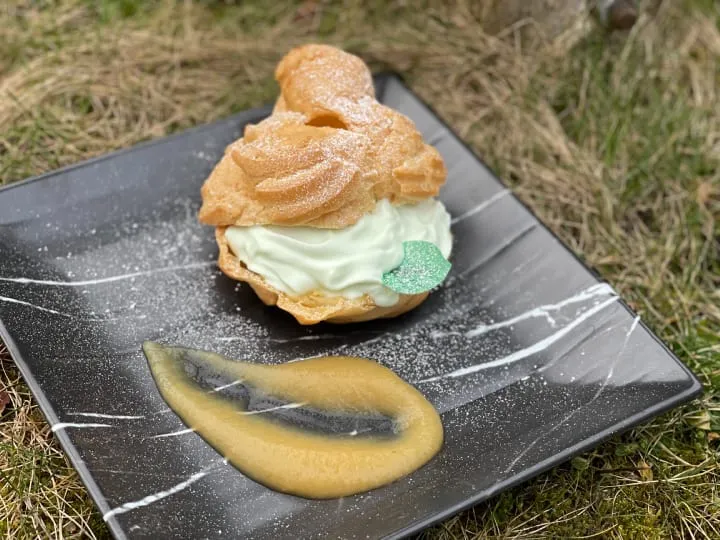 Windbeutel auf Gemüsebeet, serviert mit heller Sauce.