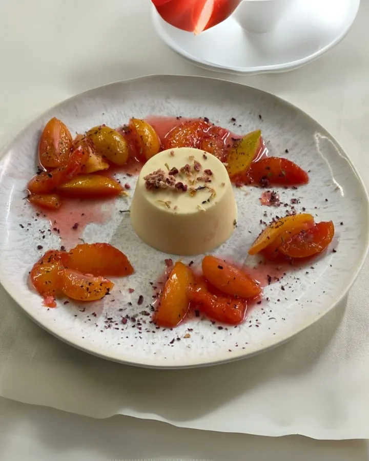 Dessertteller mit einer Creme in der Mitte, garniert mit frischen Erdbeeren und einem Minzblatt.