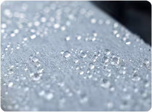 Gotas de agua brillantes sobre una superficie gris plateada