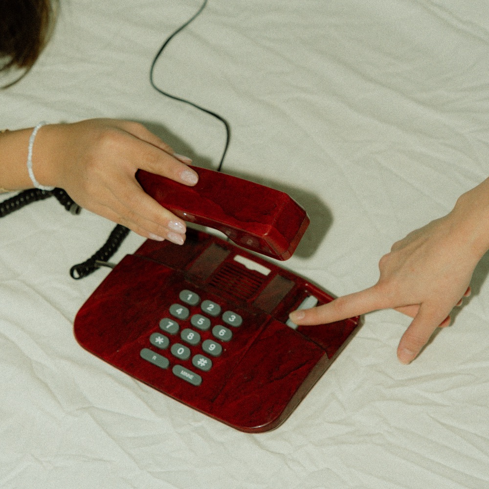 Kaksi henkilöä soittamassa punaisella lankapuhelimella. Stoore auttaa kirkastamaan yrityksesi markkinointiviestinnän, jotta potentiaalisen asiakkaan tavoittaminen ja ostopäätös helpottuvat