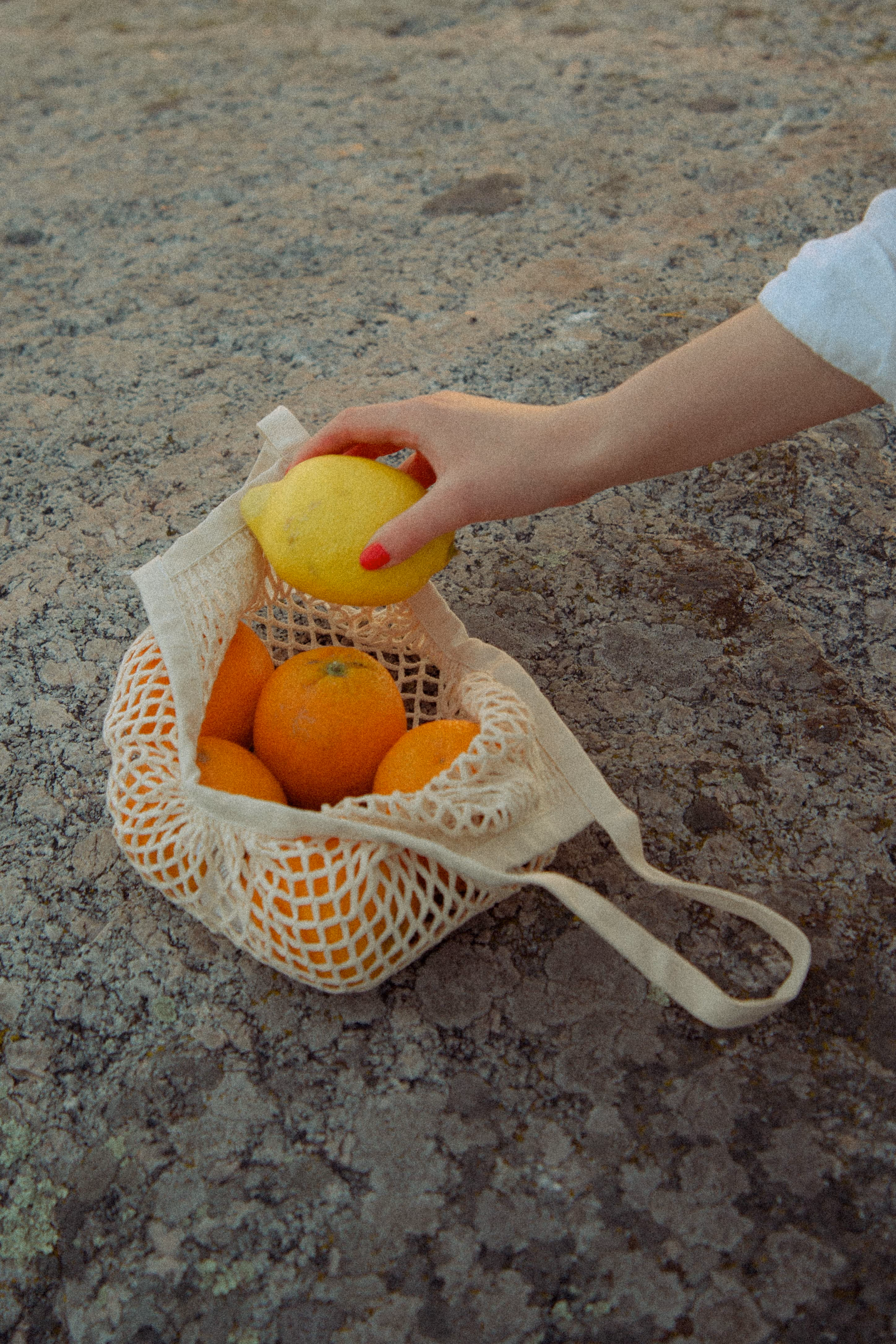 Käsi kurottamassa hedelmäkassiin kalliolla järvimaisemassa, kuvastaen Stooren jatkuvaa sisältömarkkinointia ja tuoreiden ideoiden poimimista osaksi yrityksen viestintää