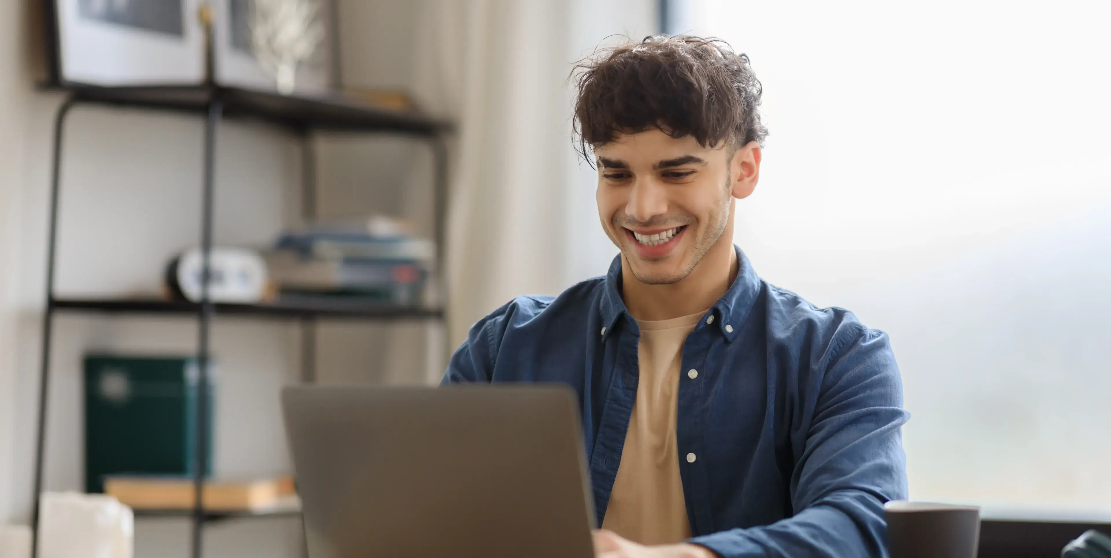A man sitting in front of a laptop computer.