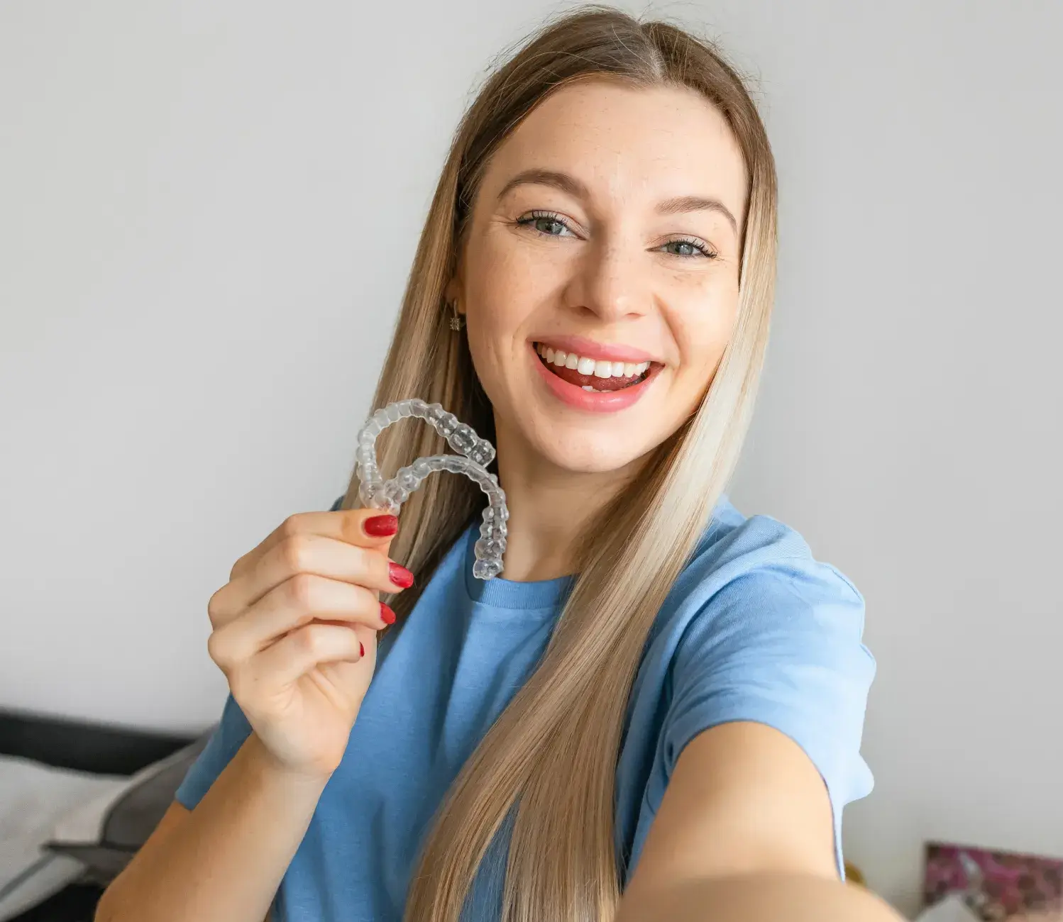 A woman holding up a pair of glasses.