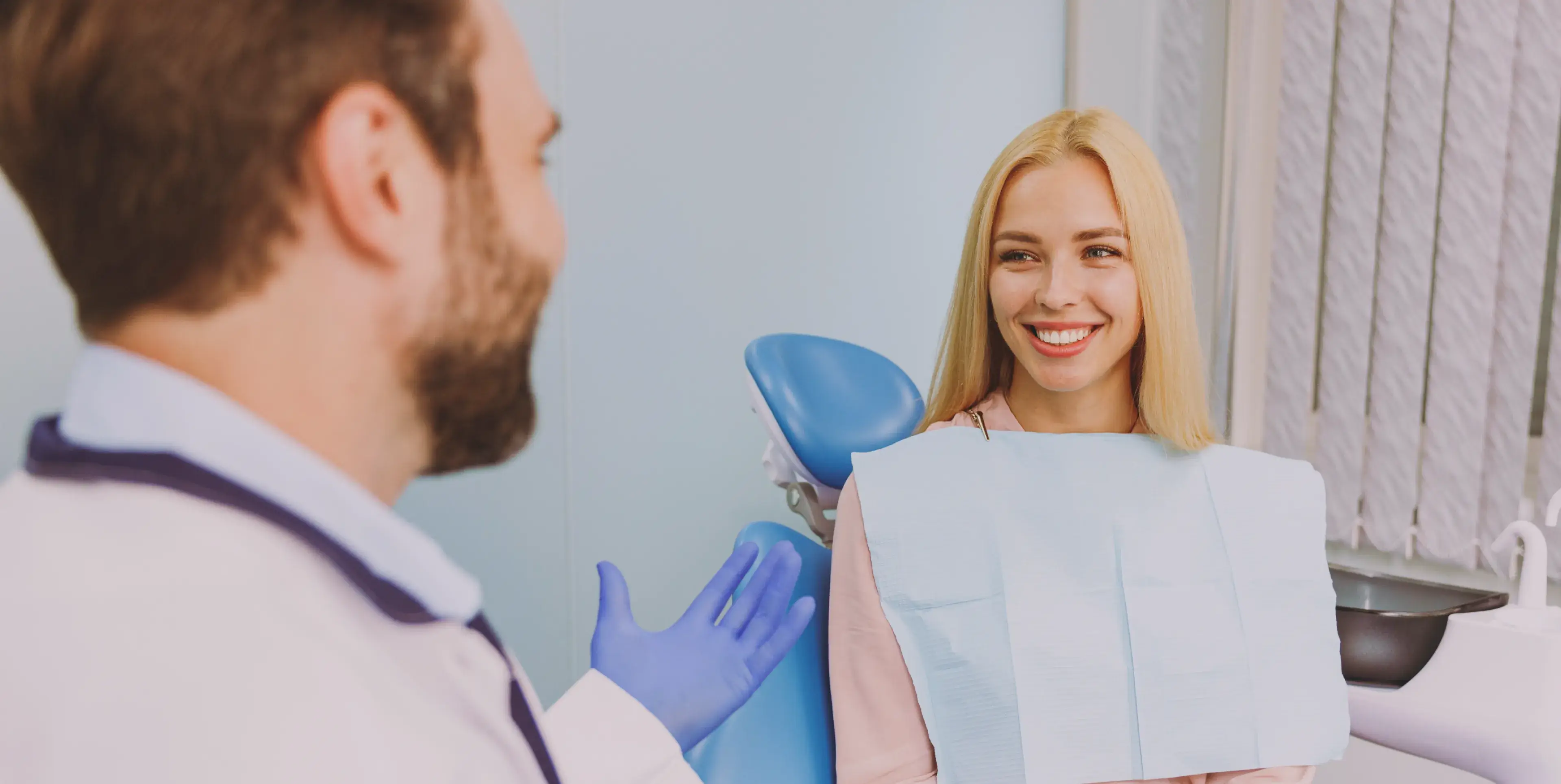 A woman is smiling while holding a toothbrush.