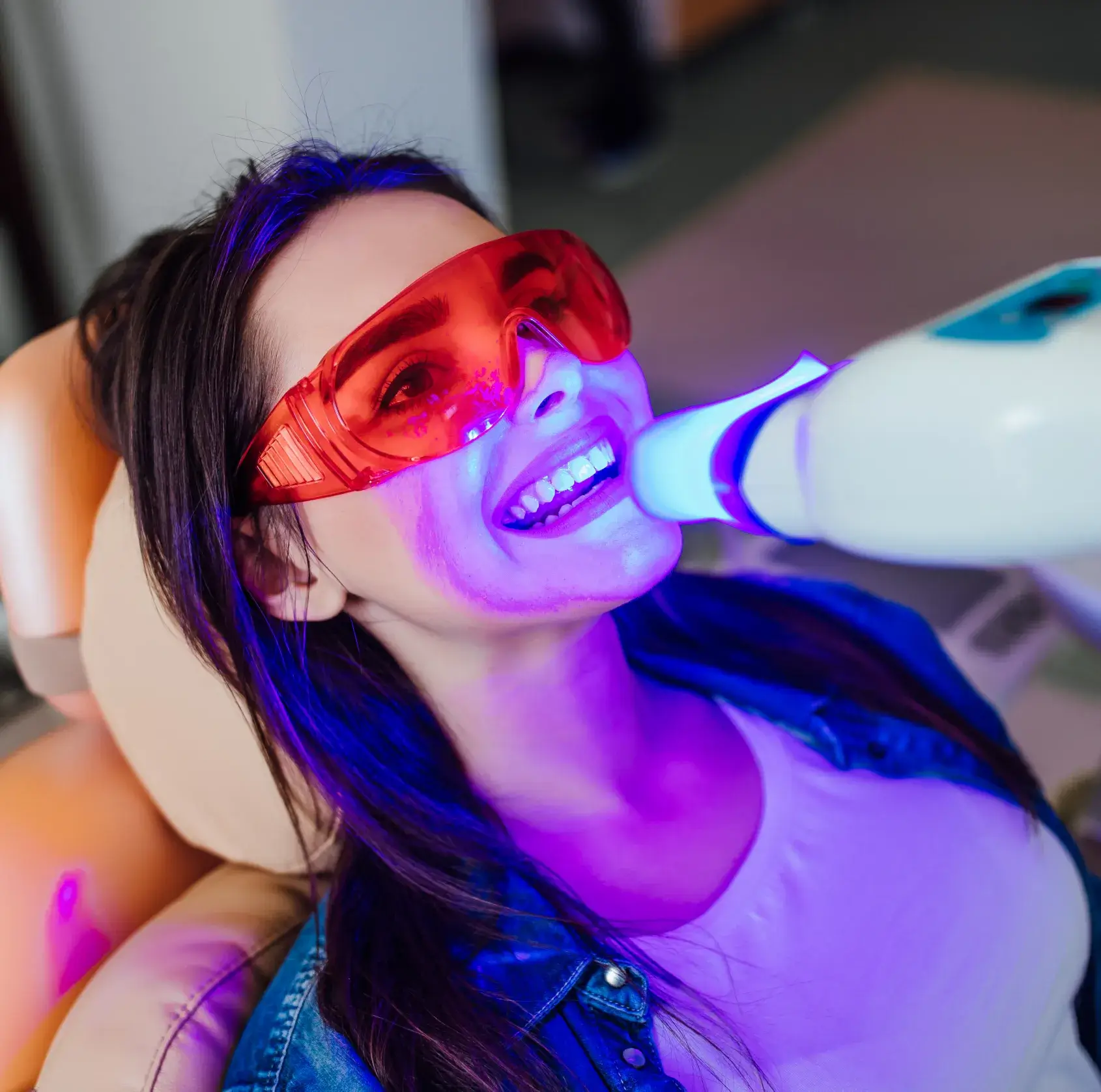 A woman wearing red glasses brushing her teeth.