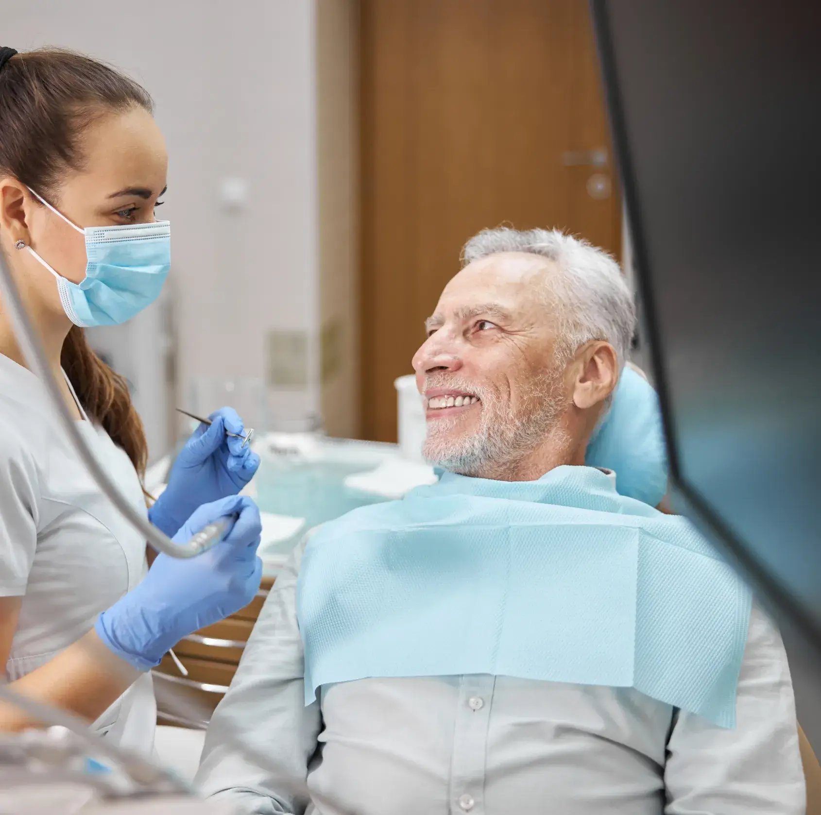 A man in a dentist chair getting his teeth checked.